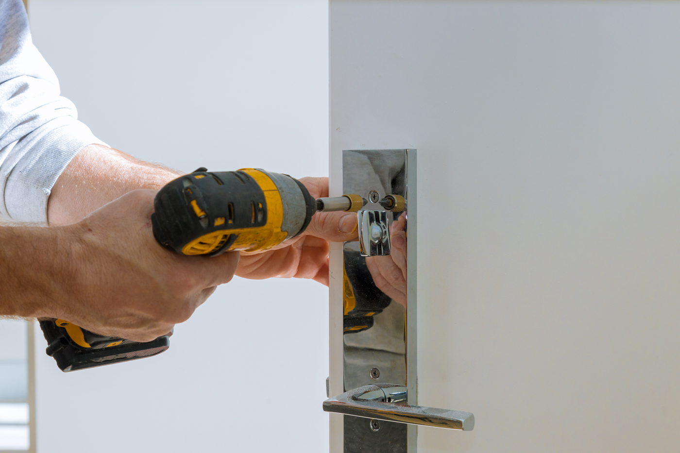 Office locksmith drilling door for lock installation