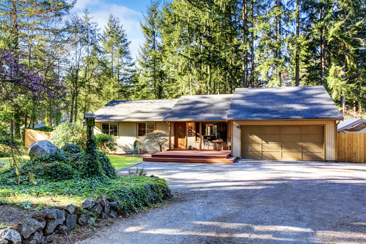 Brown residential garage door on forest home